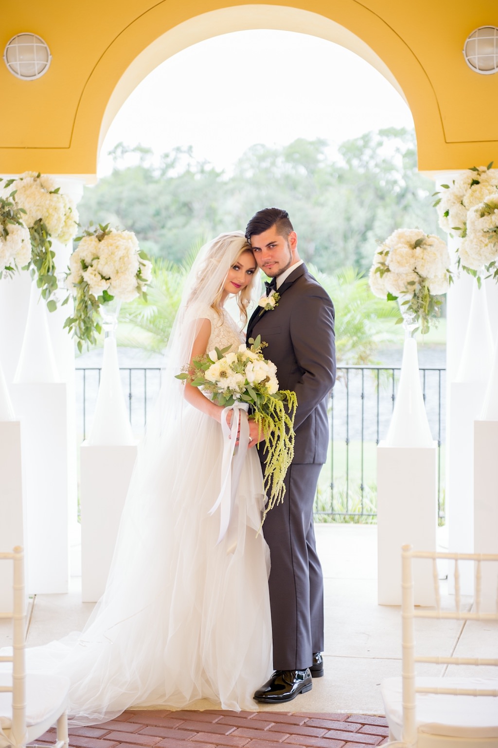 Elegant Wedding Ceremony Portrait with Tall Hydrangea Florals with Greenery in Bold White Vases on Pedestal, Bride in Ballgown Wedding Dress from Bridal Boutique The Bride Tampa, Groom in Grey Tuxedo | Tampa Bay Country Club Wedding Venue The Palms Tampa Golf & Country Club | Tampa Wedding and Event Planner Love Lee Lane | Florist and Rentals Gabro Event Services