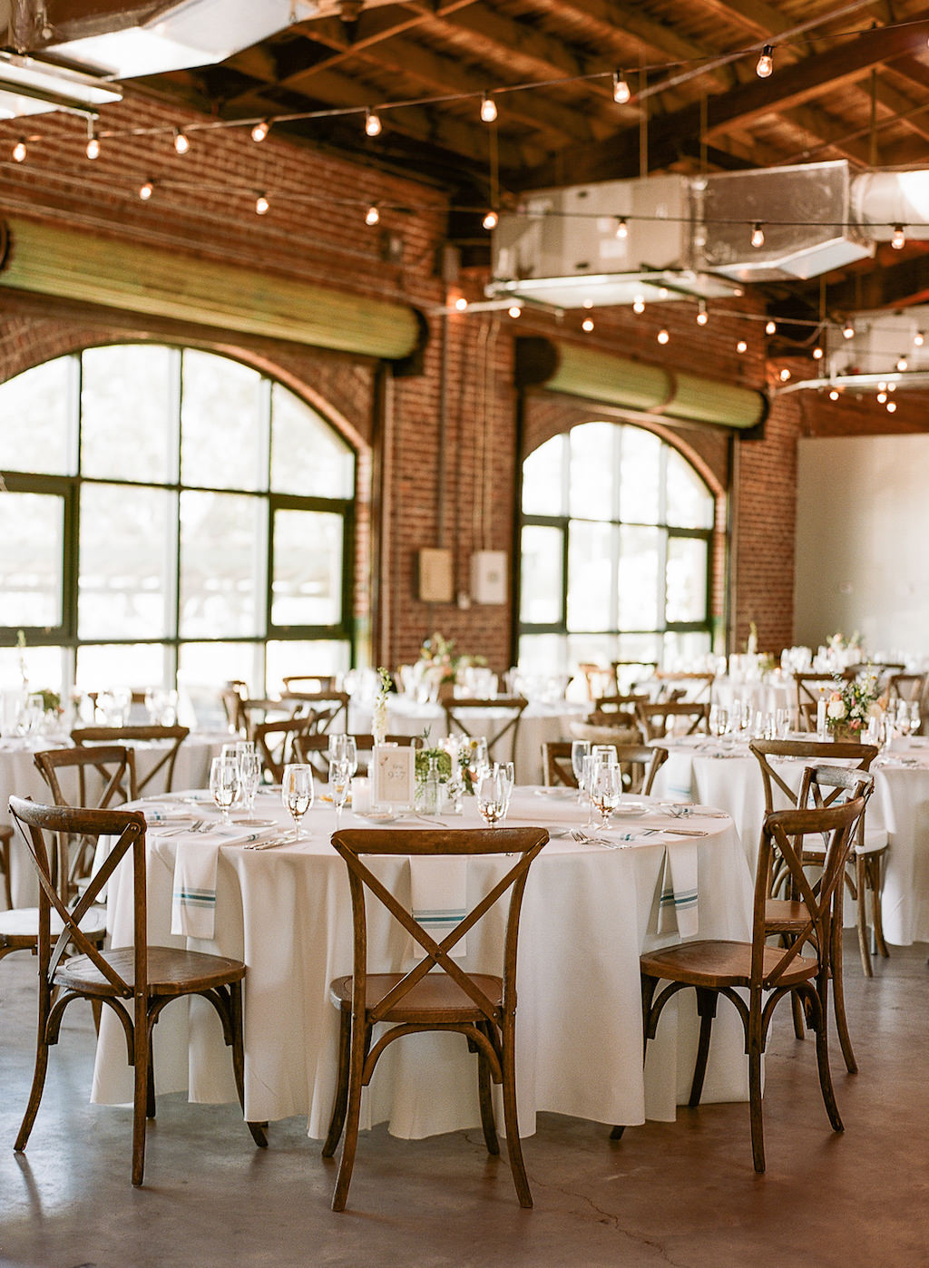 White and Teal Wedding Reception Decor with Wooden French Country Crossback Back Chairs, Teal Napkins, and String Lights | St Pete Wedding Reception Venue The Morean Center for Clay