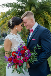 Outdoor Southern Wedding Portrait, Groom in Navy Suit with Hot Pink Bow Tie, with Red and Pink Rose with Purple Flower and Greenery Bouquet from Tampa Florist Northside Florist | Tampa Bay Wedding Photographer Caroline & Evan Photography