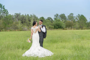 Outdoor Bride and Groom Wedding Portrait with Cutout Lace Back Stella York Wedding Dress and Yellow and White Bouquet with Greenery, Groom in Gray Suit with Light Green Tie | Tampa Wedding Photographer Kristen Marie Photography