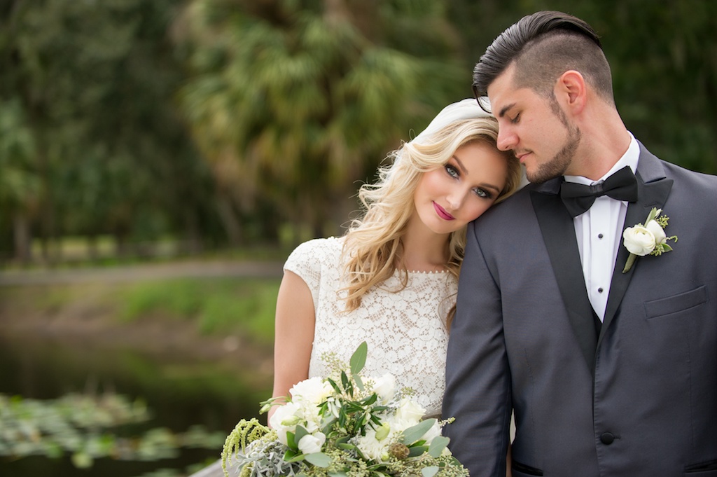 Outdoor Garden Bride and Groom Wedding Portrait, Bride in Lace Wedding Dress with White Rose and Organic Greenery Bouquet, Groom in Gray Tuxedo with White Floral with Greenery Boutonniere | Tampa Wedding Photographer Andi Diamond Photography | Tampa Wedding Florist and Rentals Gabro Event Services | Tampa Bridal Styling Hair and Makeup by Michele Renee The Studio