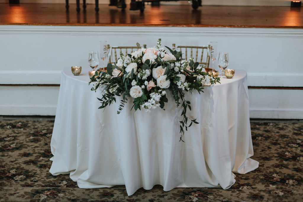 Gold and Blush Wedding Reception Bride and Groom Sweetheart Table with Gold Votive Candles and Pink and White Centerpiece with Natural Greenery | St Pete Wedding Rentals by A Chair Affair