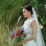 Outdoor Bridal Portrait in Floral Lace Cutout Wedding Dress with Red, Purple, and Greenery Bouquet | Tampa Bay Dress Boutique The Bride Tampa | Photography by Caroline & Evan Photography | Hair and Makeup Michele Renee The Studio