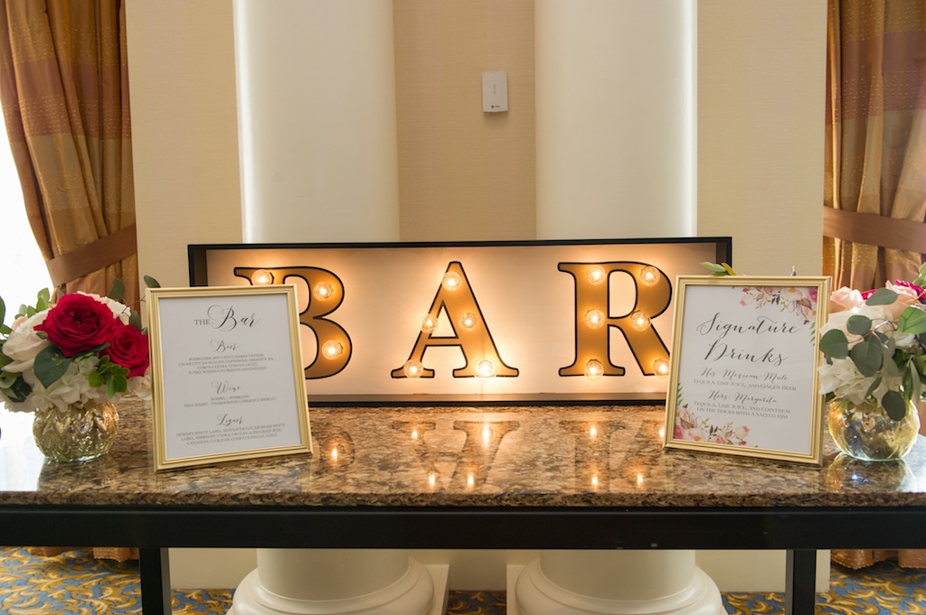 Old Florida Inspired Wedding Reception Vintage Bar Sign with Lights and Small Red and White Rose with Greenery Flowers
