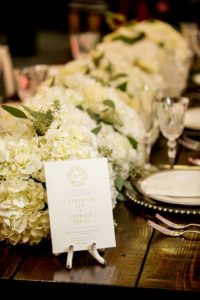 Elegant Southern Wedding Reception Table Decor Details with White Hydrangea with Greenery Garland Centerpiece on Natural Wood Farmhouse Table, and Green Floral and White Wedding Program | Tampa Bay Wedding Planner Love Lee Lane | Tampa Wedding Paper Goods Company A&P Designs | Florist and Rentals Gabro Event Services