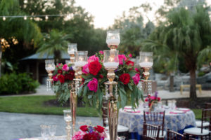 Elegant Southern Outdoor Wedding Reception Table Decor with Navy Blue, Vintage Lace, and Magenta Linens, Tall Gold Candelabra Centerpieces with Hurricane Lanterns, Red and Pink Roses, Purple Flowers and Greenery | Tampa Bay Wedding Planner Exquisite Events | Outdoor Tampa Bay Wedding Venue Southern Plantation Oasis | Northside Florist | Rentals by A Chair Affair