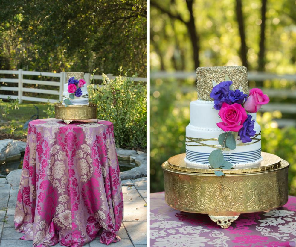 Colorful Three Tier Round White Wedding Cake with Gold Foil and Navy Stripes and Pearls on Gold Cake Stand, with Purple and Hot Pink Roses on Pink and Gold Paisley Tablecloth | Tampa Bay Wedding Cake Bakery A Piece of Cake | Over the Top Rental Linens