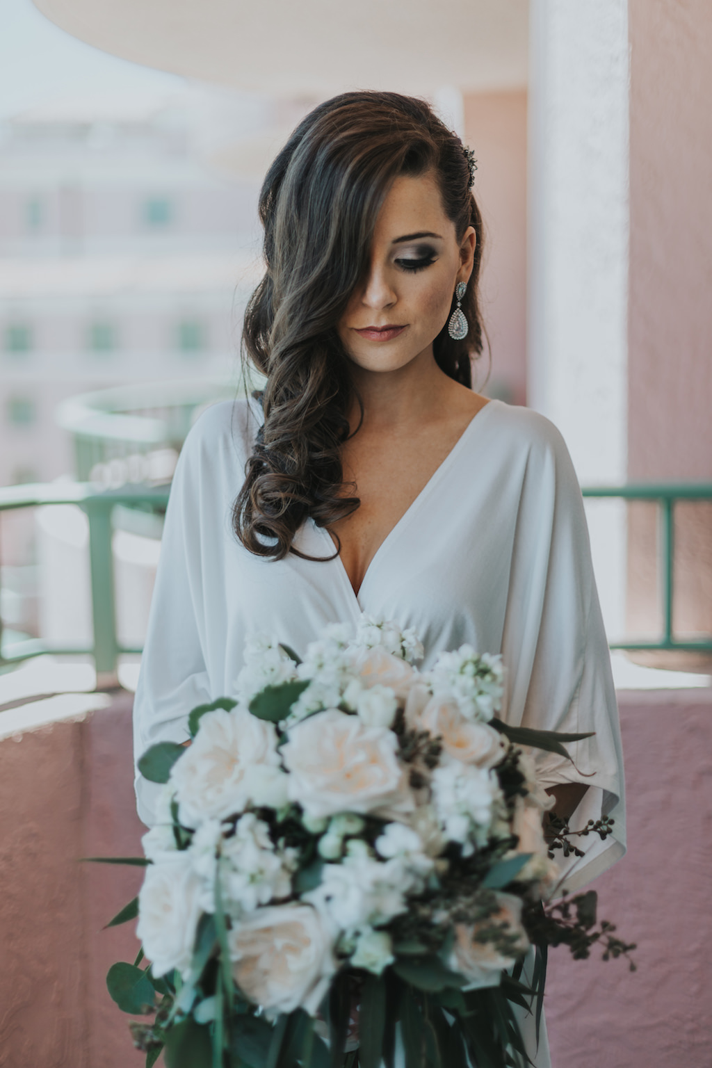 Bride Getting Ready Portrait in Silk Robe with Drop Glam Earring and Blush Pink White, and Greenery Wedding Bouquet