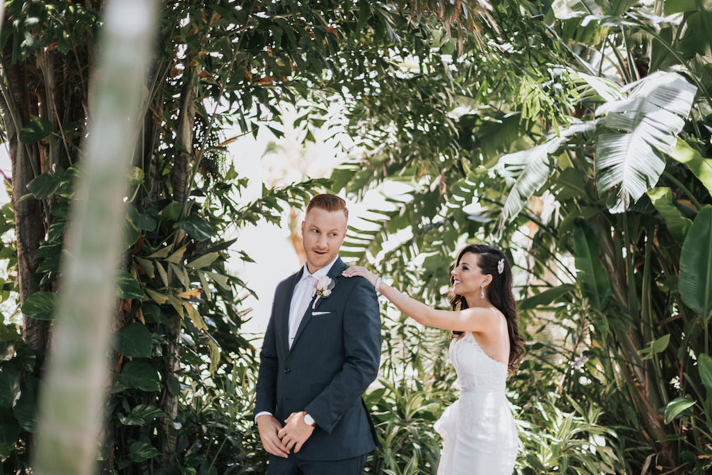 Outdoor Tropical Garden First Look Bride and Groom Wedding Portrait, Groom in Gray Suit with Blush Rose and Greenery Bouquet | Tampa Bay Wedding Getting Ready Historic Hotel Wedding Venue The Vinoy Renaissance