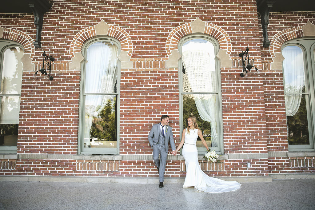 Ybor City Tampa Architectural Wedding Portrait, Groom in Grey Suit, Bride in Belted A Line Wedding Dress with White Floral and Greenery Bouquet | Tampa Bay Coastal Wedding
