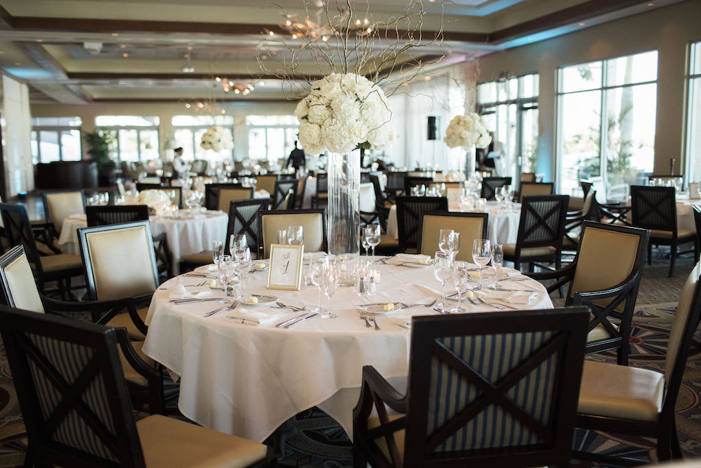 Elegant Ivory and Champagne Wedding Reception With Extra Tall White Hydrangea and Natural Branch Centerpiece in Wide Glass Vase with Gold Framed Table Number | Sarasota Wedding Venue Sarasota Yacht Club | Tampa Bay Wedding Planner NK Productions