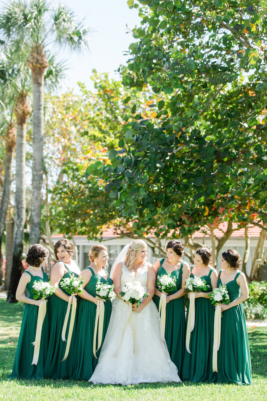 White, Gold and Green Old Florida Inspired Wedding Party Outdoor Garden Portrait, Bridesmaids in Watters Dresses, Bride in V Neck Morilee by Madeline Gardner Wedding Dress, with White Floral Bouquets with Greenery and Long Gold Ribbons | Tampa Bay Wedding Photographer Ailyn La Torre Photography