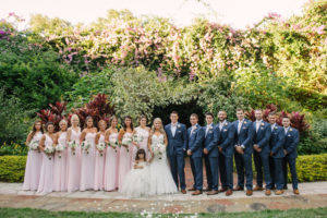 Outdoor Tropical Garden Wedding Party Portrait, Bridesmaids in Mismatched Floorlength Blush Dresses, Groomsmen in Navy BLue Suits with Brown Shoes and Blush Pink Bowtie and Pocket Square | St Pete Outdoor Wedding Ceremony Venue Sunken Gardens