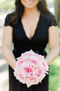 Outdoor Garden Bridesmaid Portrait in V Neck Cap Sleeve Lace Black Belted David's Bridal Dress with Pink Rose Bouquet