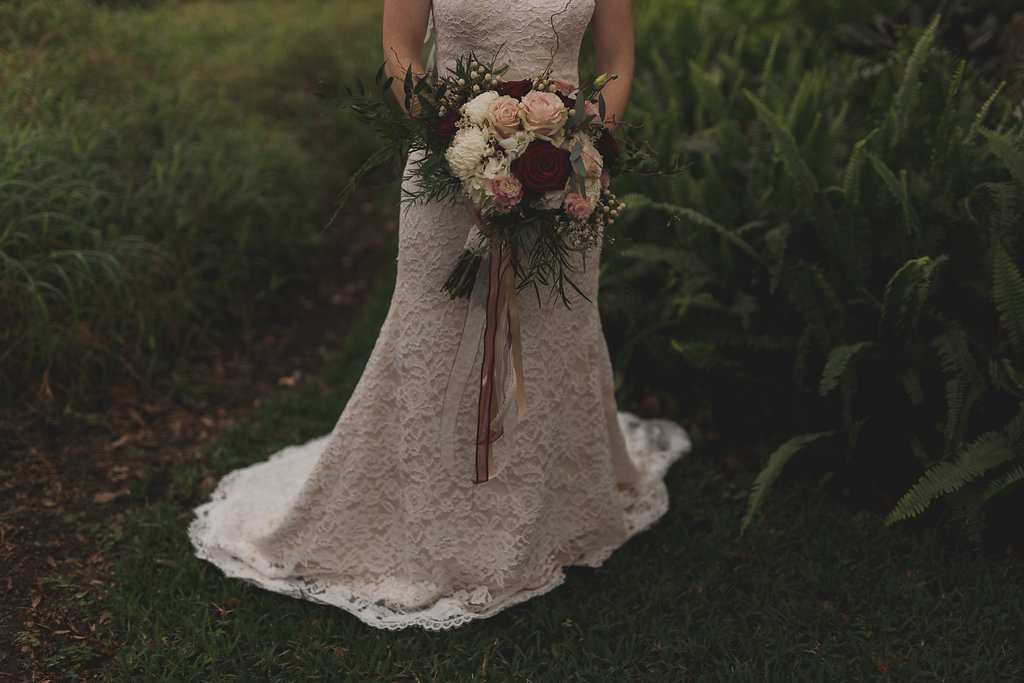 Outdoor Bridal Portrait in Floral Lace A Line Wedding Dress with Blush, Ivory, and Maroon Rose Bouquet with Baby's Breath and Natural Greenery with Hanging Champagne and Maroon Ribbons | Tampa Wedding Photographer Stacy Paul Photography