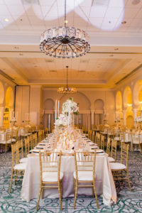 Gold and Ivory with Black and Blush Accent Hotel Ballroom Wedding Reception Long Feasting Table with Tall White, Pink and Greenery Centerpiece and Tall Candleholders with Gold Chiavari Chairs and Blush Linens | Downtown St Pete Beach Hotel Wedding Venue The Vinoy Renaissance | Tampa Bay Wedding Planner Love Lee Lane