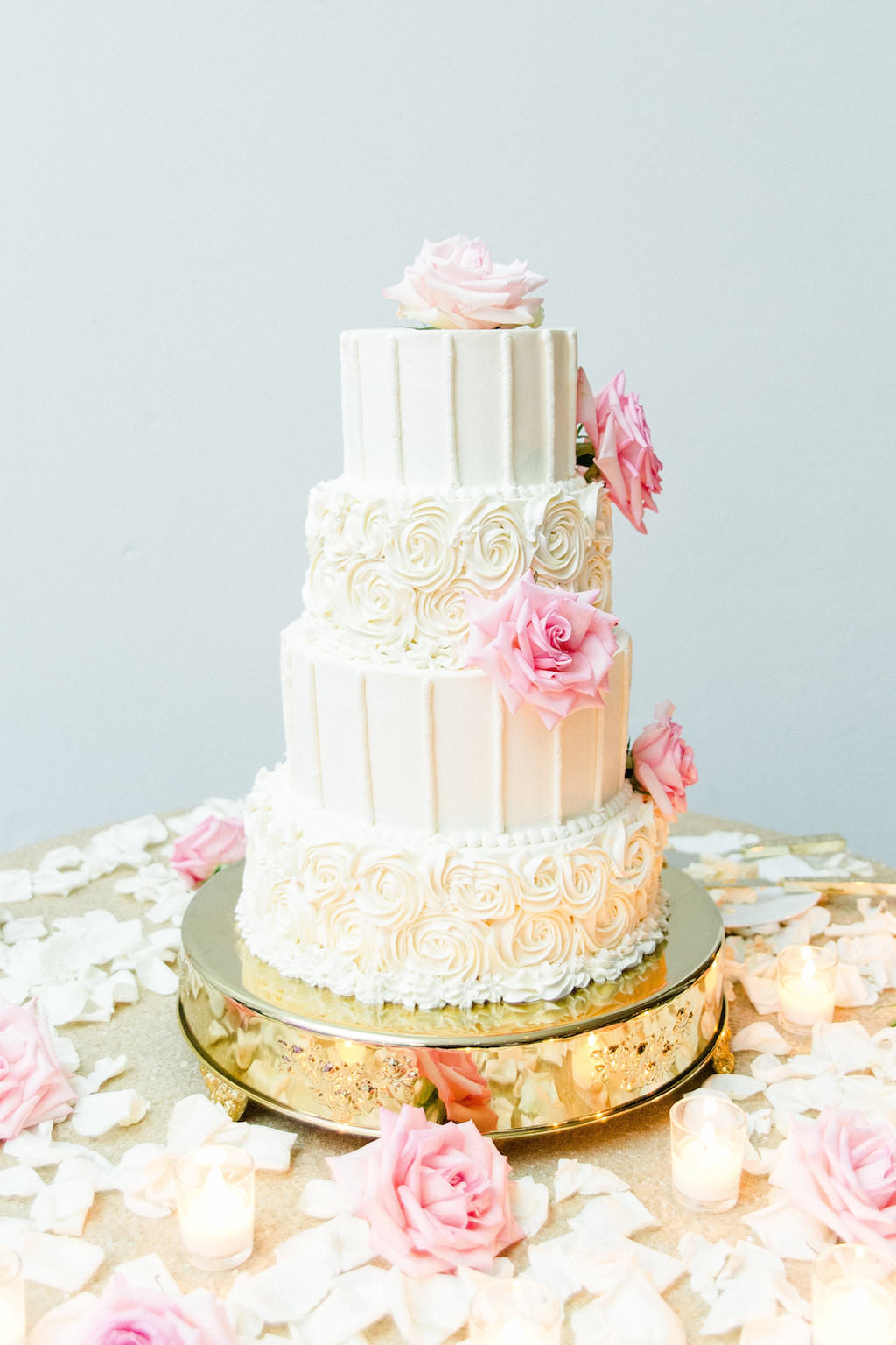 Elegant, Classic Four Tier Round White Wedding Cake with Alternating Rose and Vertical Icing and Pink Roses and Ivory Rose Petals on Gold Cake Stand | Wedding Cake Baker The Vinoy Renaissance