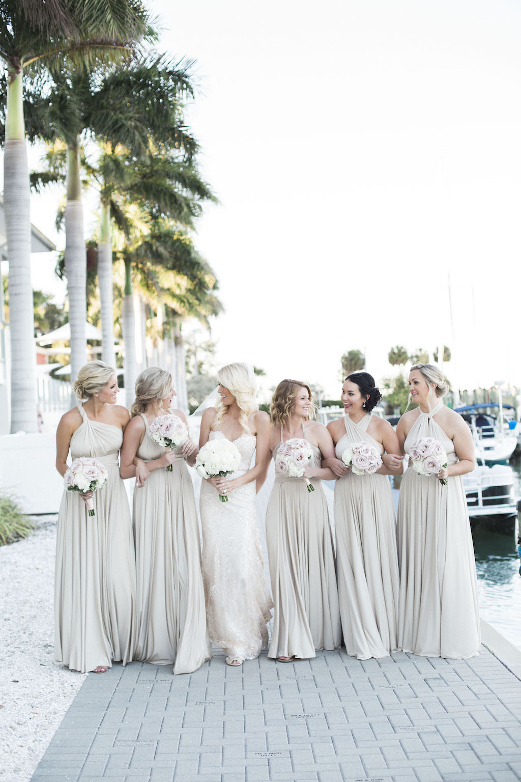 Outdoor Waterfront Bridal Party Portrait, Bridesmaids in Mismatched Ivory Floor Length Dresses with Blush and White Bouquets | Sarasota Wedding Venue Sarasota Yacht Club | Wedding Planner NK Productions