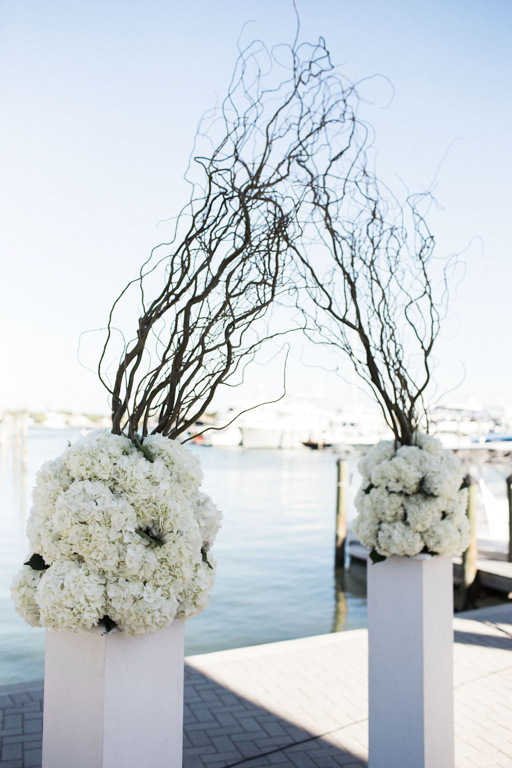 Waterfront Wedding Ceremony Decor with White Hydrangeas on Pedestals with Natural Branches | Sarasota Wedding Planner NK Productions