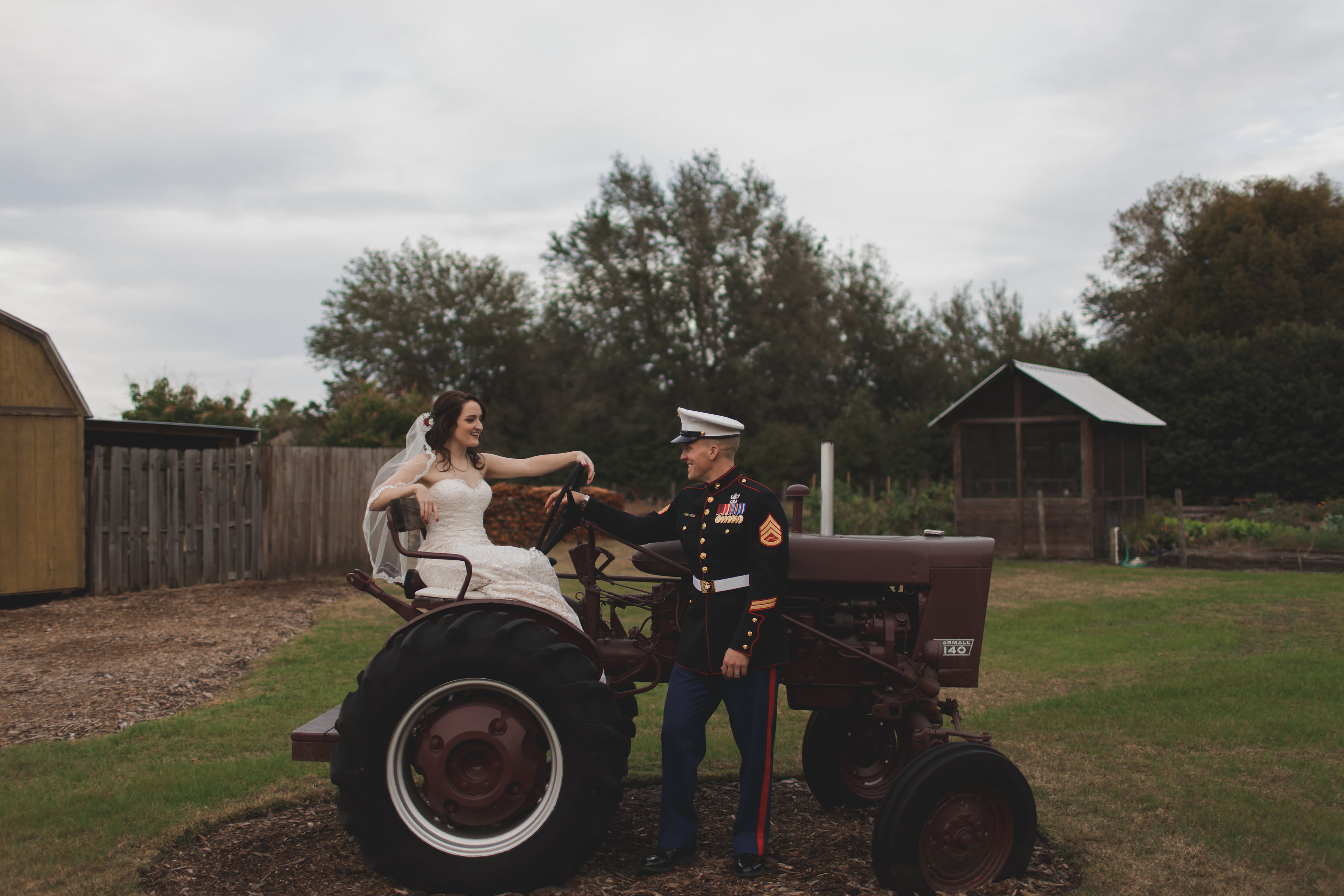Rustic Farm Wedding Outdoor Bride and Groom Portrait with Tractor, Bride in Strapless Stella York Wedding Dress with Long Veil, Groom in Marine Dress Uniform | Tampa Bay Wedding Photographer Stacy Paul Photography