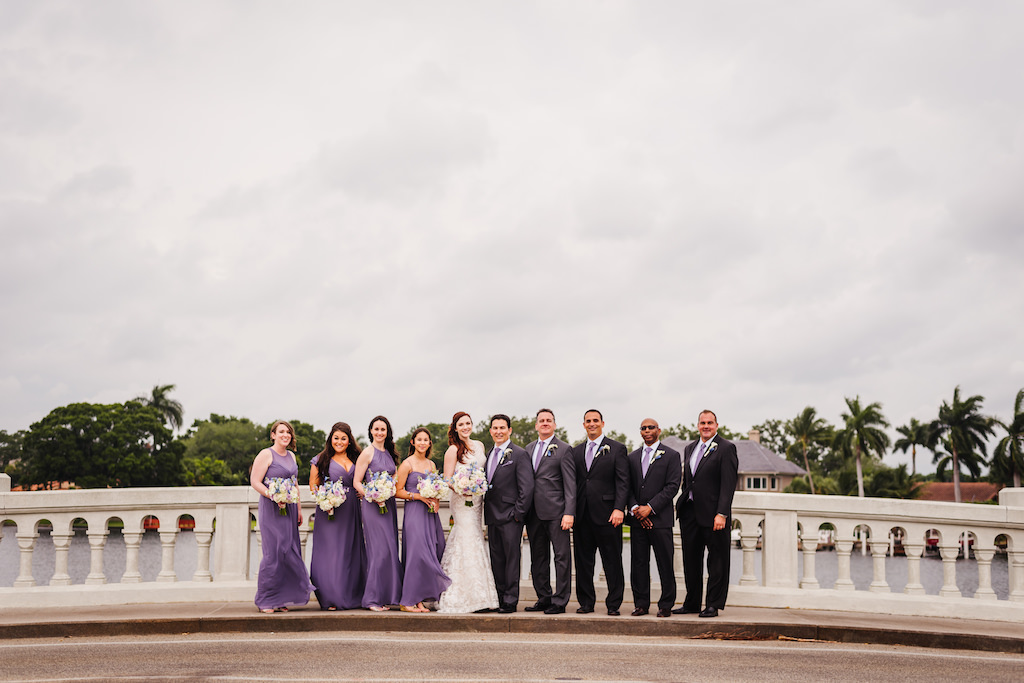 Outdoor Downtown St Pete Waterfront Wedding Party Portrait, Bridesmaids in Mismatched Dusty Purple Dessy Dresses, Groomsmen in Grey and Black Suits with Pastel Purple Ties
