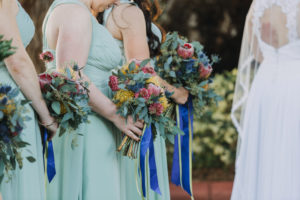 Mediterranean Blue and Green Garden Wedding Ceremony Portrait, Bridesmaids in Sage Azazie Dresses with Pink, Yellow and Greenery Bouquets with Cobalt Ribbons