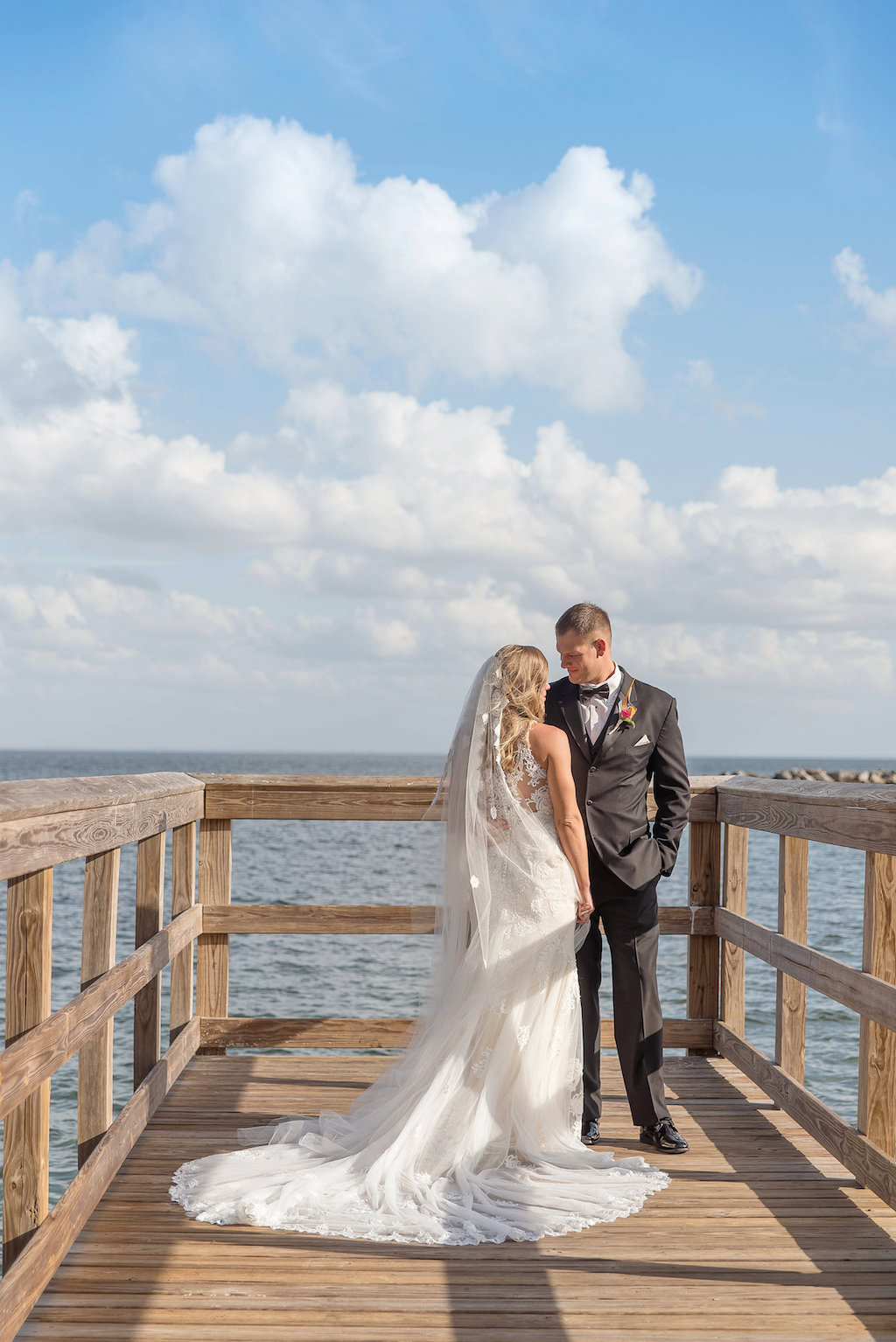 Old Florida Themed Outdoor Waterfront Bride and Groom Wedding Portrait on Dock, Bride in Cathedral Train Essence of Australia Wedding Dress with Floorlength Veil | St Pete Wedding Photographer Kristen Marie Photography