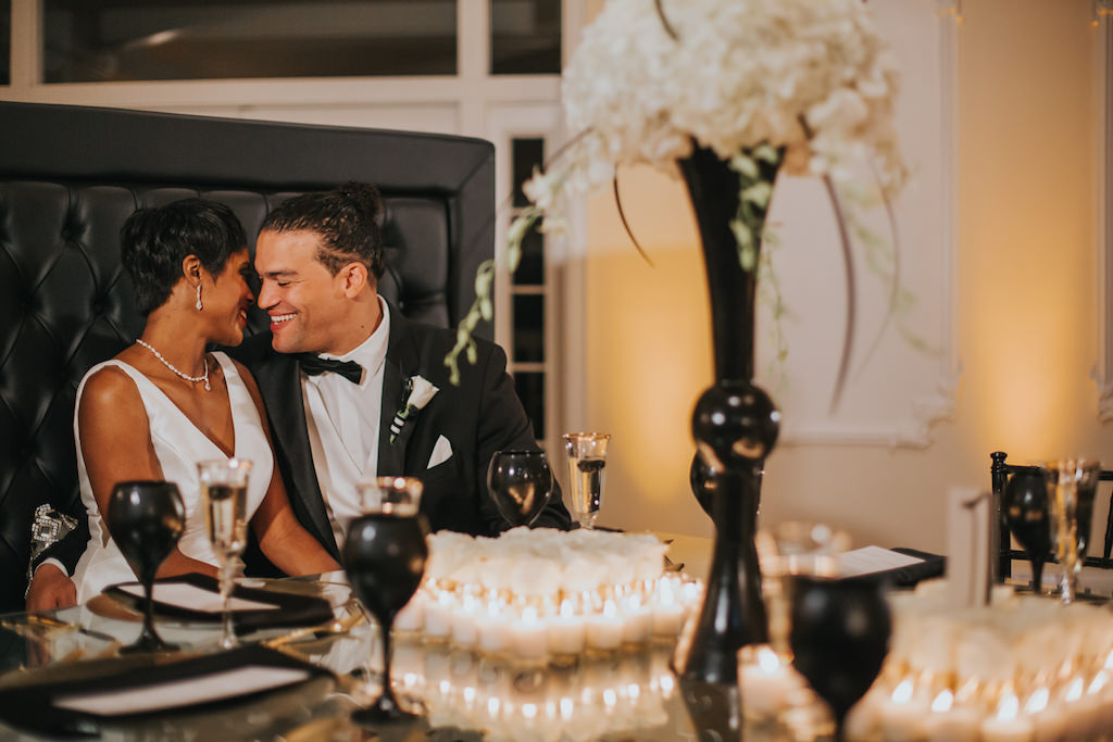 Modern, sophisticated Black, White, and Gold Wedding Reception Portrait, with Black Wine Glasses and Tall White Hydrangea Centerpiece in Black Vase | Tampa Bay Wedding Photographer Brandi Image Photography | Planner UNIQUE Weddings and Events
