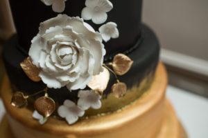 Modern, Sophisticated Black, White and Gold Round Wedding Cake with Black to Gold Ombre Icing and White Peony with Gold Leaves | Tampa Bay Wedding Cake Bakery Alessi Bakery