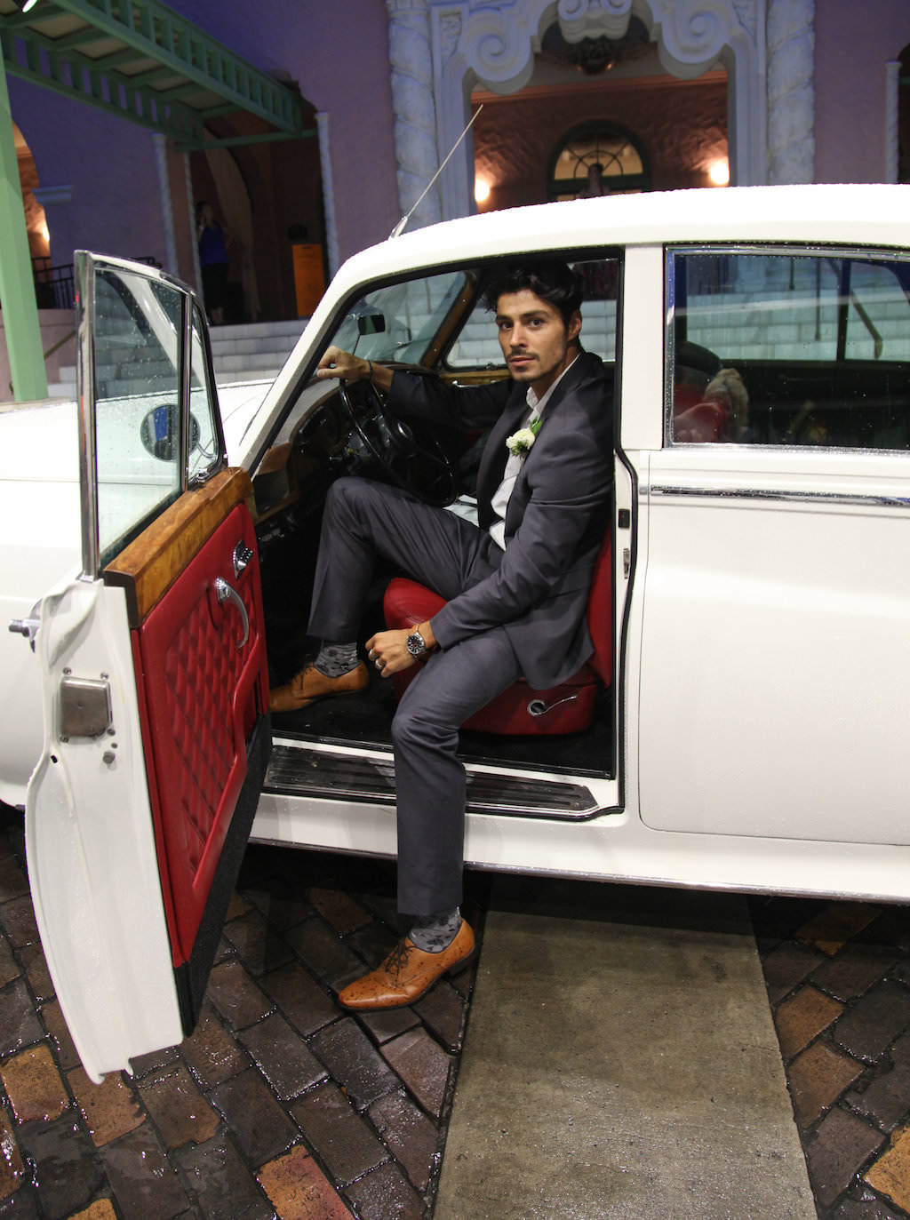 Groom Wedding Exit Portrait in Classic Vintage Car, Wearing Gray Suit with Tan Leather Shoes and WHite Floral Boutonniere