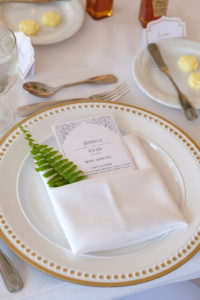 White, Gold and Greenery Wedding Reception Table Decor with Green Fern, Gold Rimmed White Porcelain Charger, and Elegant Blue and White Printed Menu