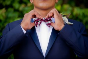 Outdoor Garden Groom Portrait In Blue Suit with Burgundy Plaid Bow Tie and Anemone and Greenery Boutonniere | Tampa Bay Wedding Photographer Andi Diamond Photography | Mens Suit Sacinos Formalwear