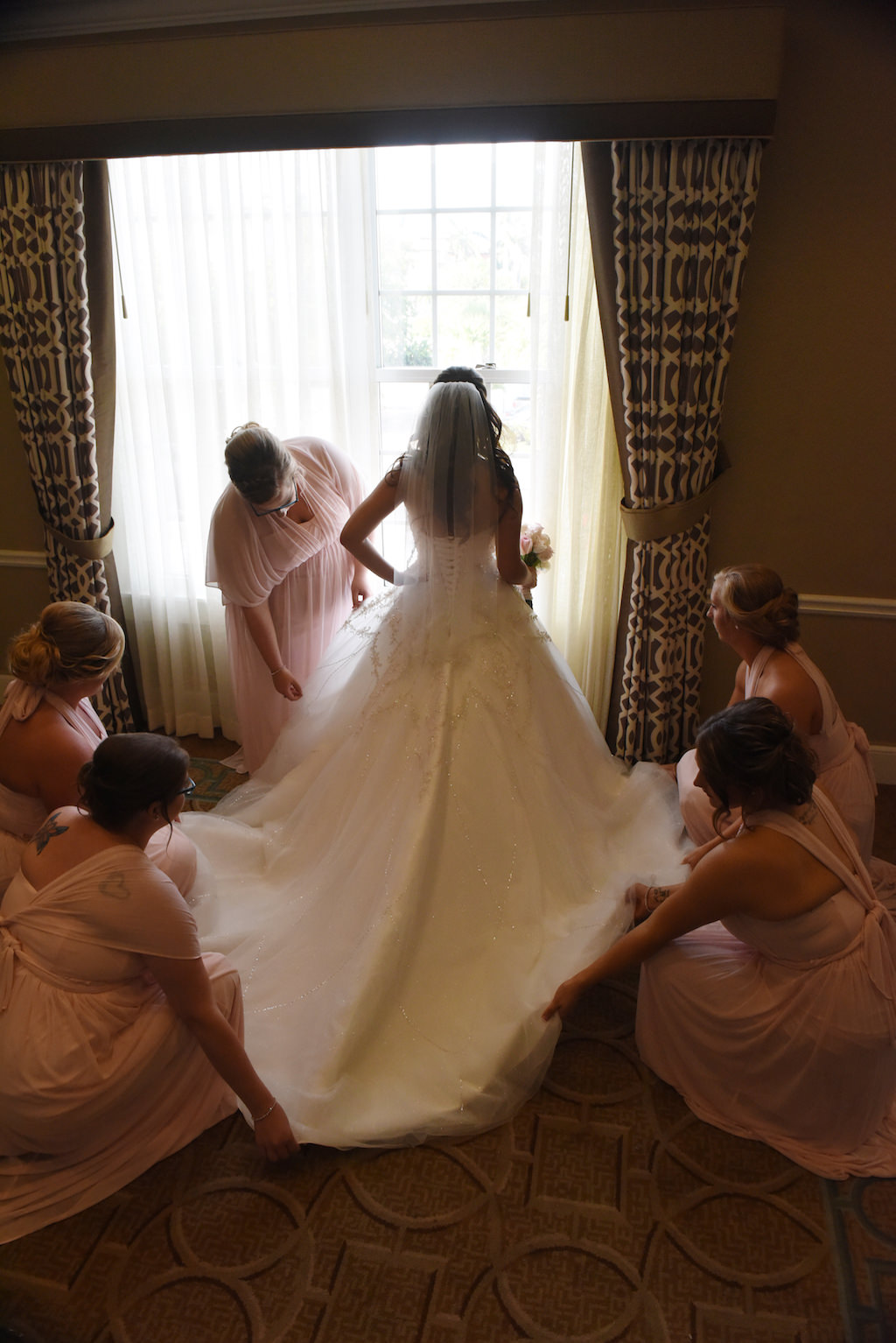Interior Bride Getting Ready Portrait in Long Train Wedding Dress, Bridesmaids in Mismatched Blush Pink David's Bridal Dresses