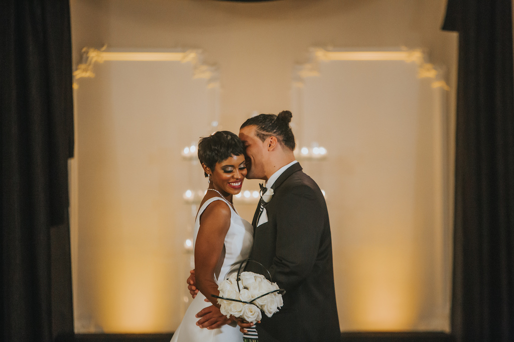 Modern, Sophisticated Black and White Wedding Ceremony Portrait with White Rose Bouquet with Black and White Ribbon, Groom in Black Tux from Sacino's Formalwear | Tampa Bay Wedding Photography Brandi Image Photography | Bridal Beauty Hair and Makeup Michele Renee The Studio