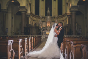 Traditional Church Wedding Ceremony, With White and Greenery Flower Arrangements Bride in Pronovias Layered Mermaid Strapless Dress | Downtown Tampa Wedding Ceremony Venue Sacred Heart Catholic Church