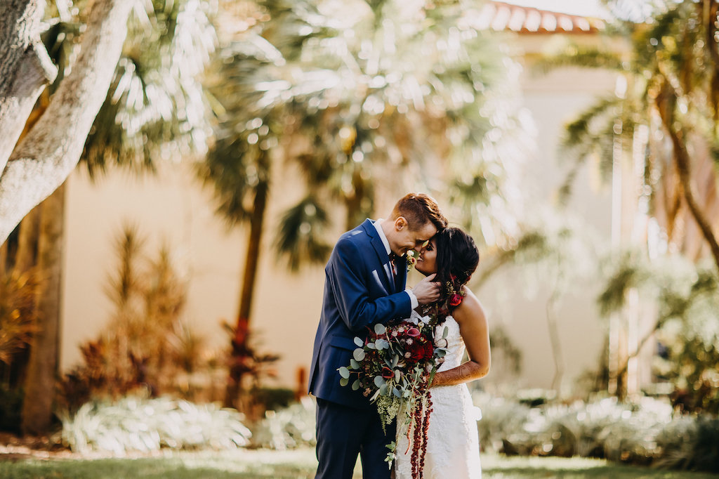Blue and Red Modern Indian Wedding Outdoor First Look Portrait, Bride in Lace Strapless Davids Bridal Dress, Groom in Navy Suit with Red Tie and Boutonniere, Red and Plum Floral with Greenery Bouquet | St Pete Wedding Photographer Rad Red Creative | Menswear Sacino's Formalwear