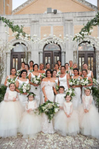 Outdoor Bridal Party Portrait, Bridesmaids in Floorlength White Hayley Paige Bella Bridesmaids Dresses, Flower Girls in Blush Pink Dresses with Layered Skirts, under hanging White Flowers, Greenery, and Wild Branch Arches | Tarpon Springs Wedding Venue St Nicholas Greek Orthodox Church