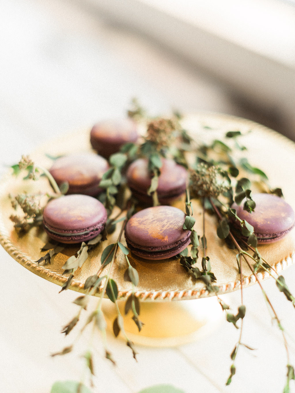 Modern Wedding Dessert Gold and Purple Macaroons on Gold Cake Stand with dried greenery