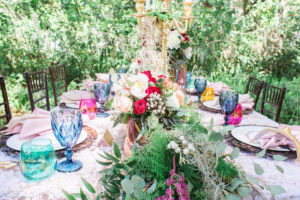 Outdoor Whimsical Boho Garden Wedding Reception Decor with Vintage Mismatched Dishes and Garland Floral Table Runner
