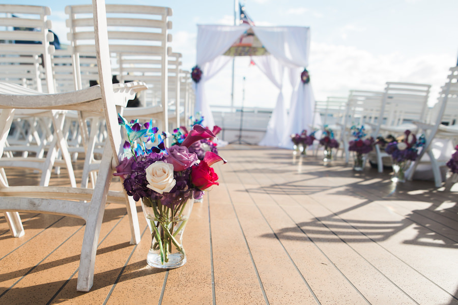 Outdoor Wedding On the Water Wedding Ceremony with White Folding Chairs, White Draped Chuppah Wedding Arch with Purple, Blue, White, and Red Flower Arrangements | Downtown Tampa Nautical Wedding Venue Yacht StarShip