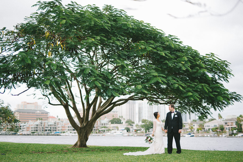 Outdoor Bride and Groom Wedding Portrait, Bride with Red and White Rose with Greenery Bouquet | Tampa Bay Waterfront Wedding Venue Davis Island Garden Club | Photographer Kera Photography
