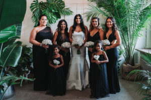 Modern Indian Wedding Bridal Party Portrait, Bridesmaids and Flower Girls in Mismatched Floor Length Black Dresses, Bride in Strapless Mermaid Wedding Dress, with White Rose Bouquet | Tampa Wedding Photographer Grind and Press Photography