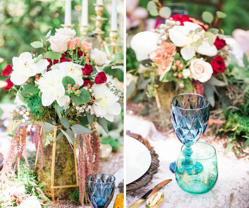 Outdoor Whimsical Boho Garden Wedding Reception Decor with Red and White Centerpiece in Geometric Vase with Moss and Vintage Blue Glasses