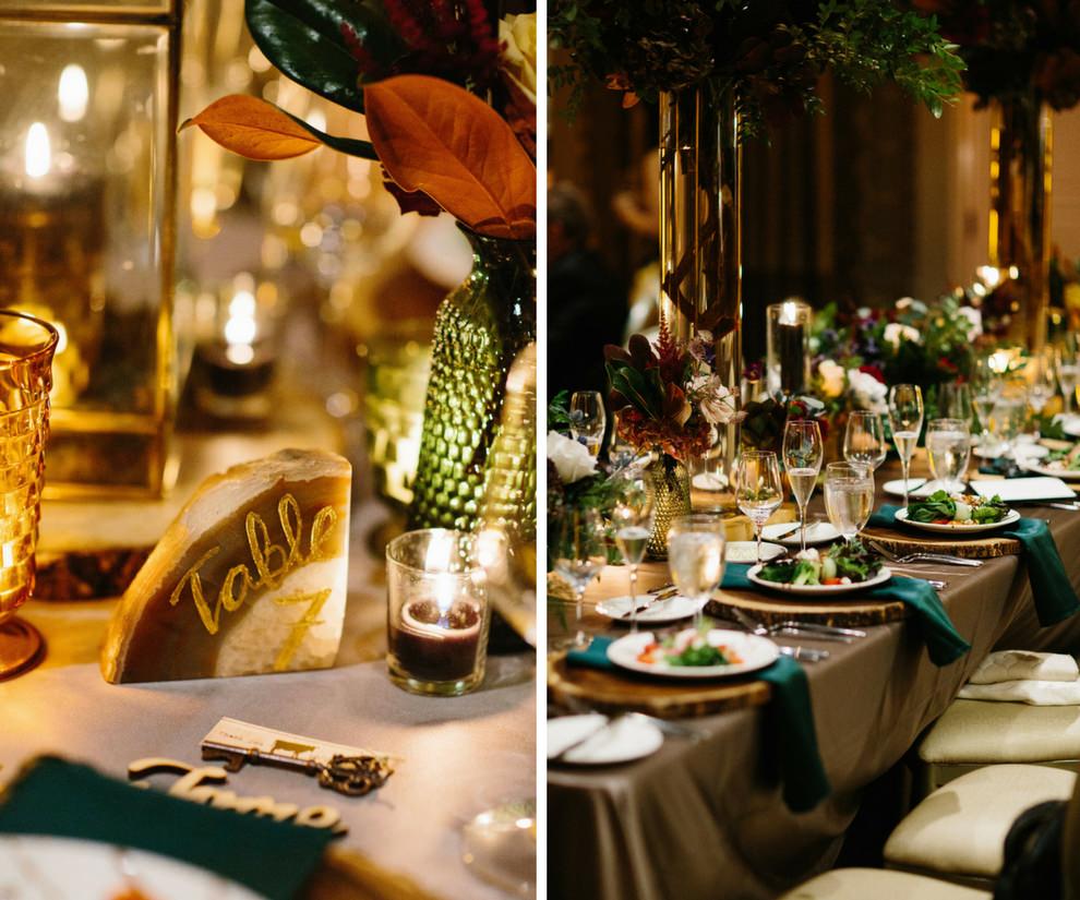 Forrest Inspired Natural Jewel Tone Wedding Reception Table Decor with Gold Painted Geode Table Number, Emerald Green Napkins and Mauve Satin Tablecloth, and Tall Branch and Greenery Centerpieces in Tall Glass Cylinder Vases