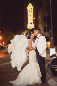 Outdoor Nighttime Downtown Tampa Bride and Groom Portrait, Bride in Lace Layered Mermaid Ines Di Santo Dress, Groom in White Tuxedo with Hora Loca Props Angel Wings | Tampa Bay Wedding Planner Special Moments Event Planning | Dress Shop Isabel O'Neil Bridal