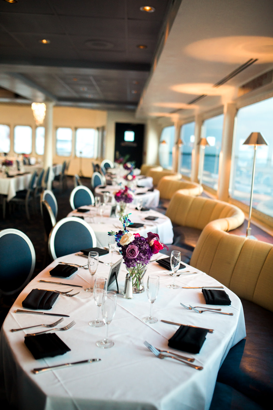 Yacht Dining Room Wedding Reception with Black LInens, and Small Purple, White, Fuchsia, Blue and Red Floral Centerpieces in Glass Vases | Tampa Bay Nautical Wedding Venue The Yacht Starship