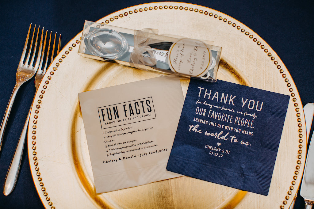 Navy Blue and Gold Wedding Reception Paper Goods with Custom Blue Napkin with Gold Writing, and Engraved Silver Spoon Favor on Gold Charger