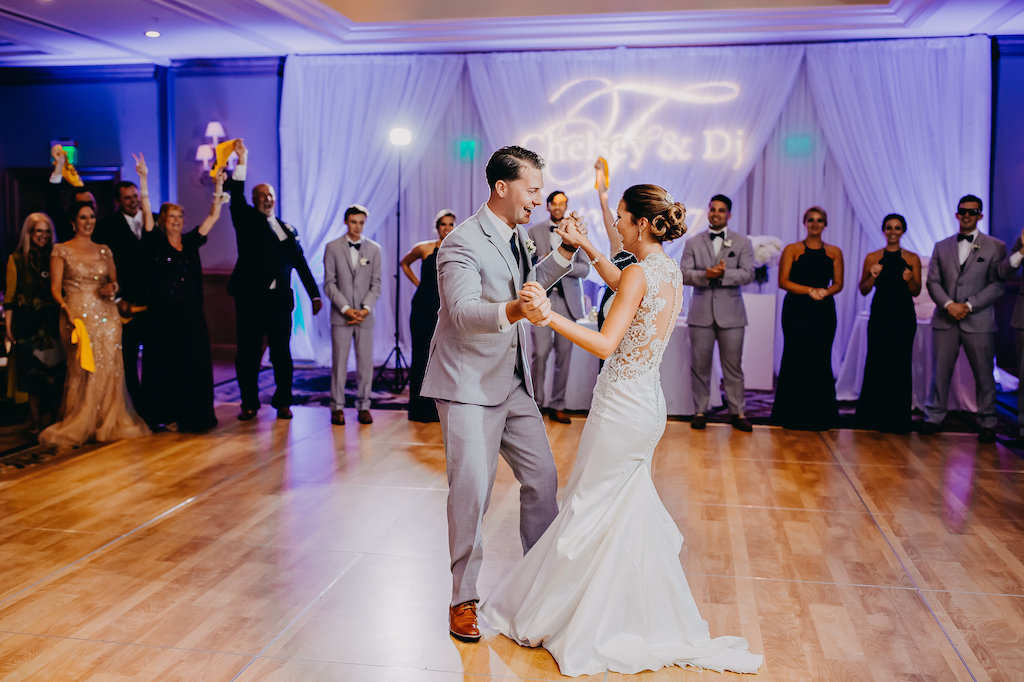 Hotel Ballroom Wedding Reception Bride and Groom First Dance Portrait, with Custom Name Light Projection, Groom in Gray Suit | Tampa Bay Wedding DJ, Lighting, and Rentals Gabro Event Services | Clearwater Beach Wedding Photography Rad Red Creative