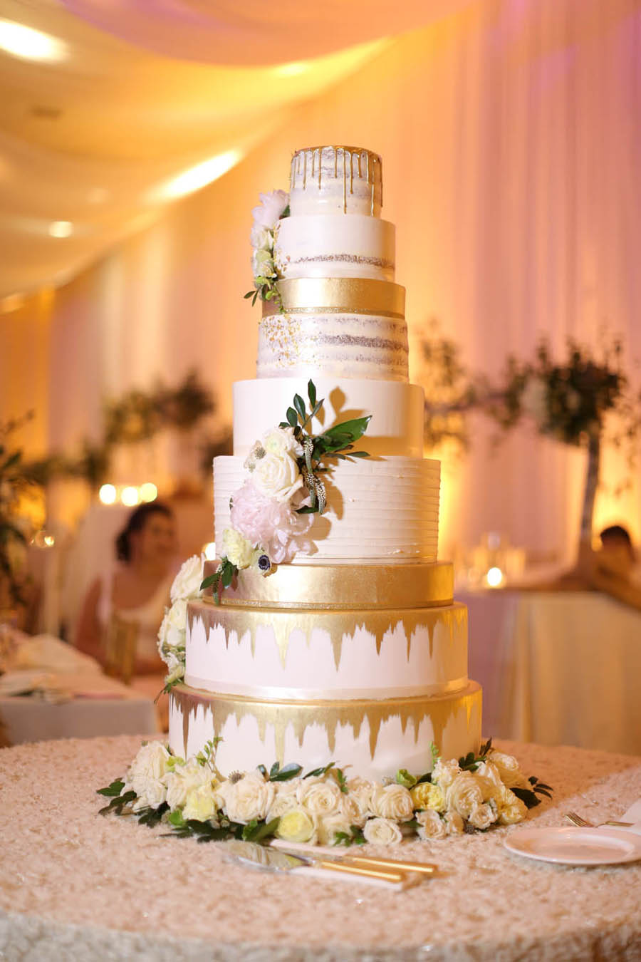 Nine Tier Round White Wedding Cake with Gold Dripping Frosting, White Florals with Greenery | Tarpon Springs Wedding Bakery Artistic Whisk