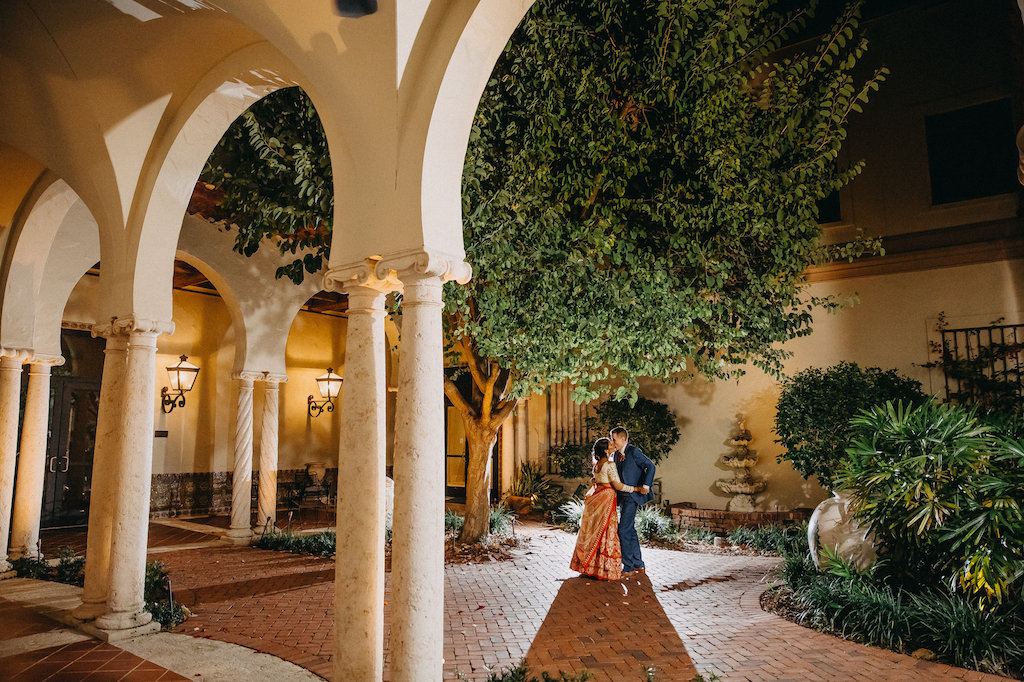 Modern Indian Wedding Courtyard Garden Nighttime Outdoor Wedding Portrait, Bride in Red and Gold with White Saree, Groom in Blue Suit | St Pete Wedding Photographer Rad Red Creative | Venue St Petersburg Museum of Fine Arts